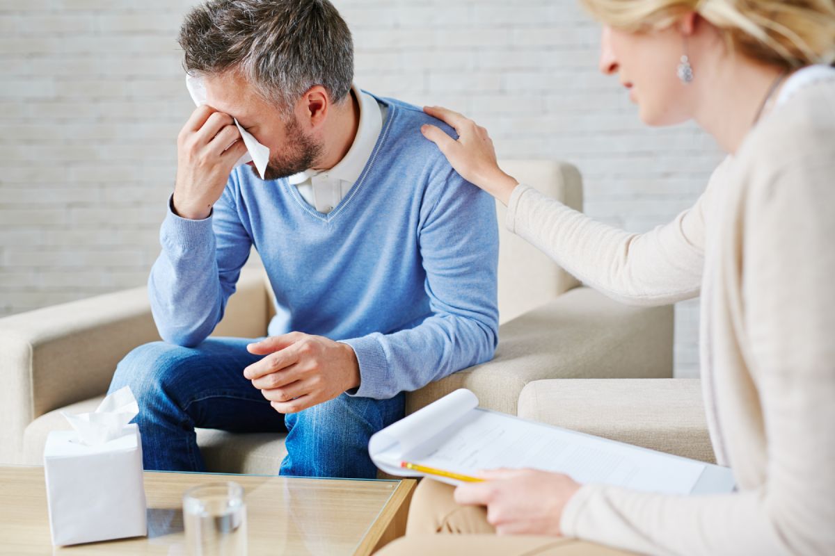 Depressed man crying while visiting his psychologist