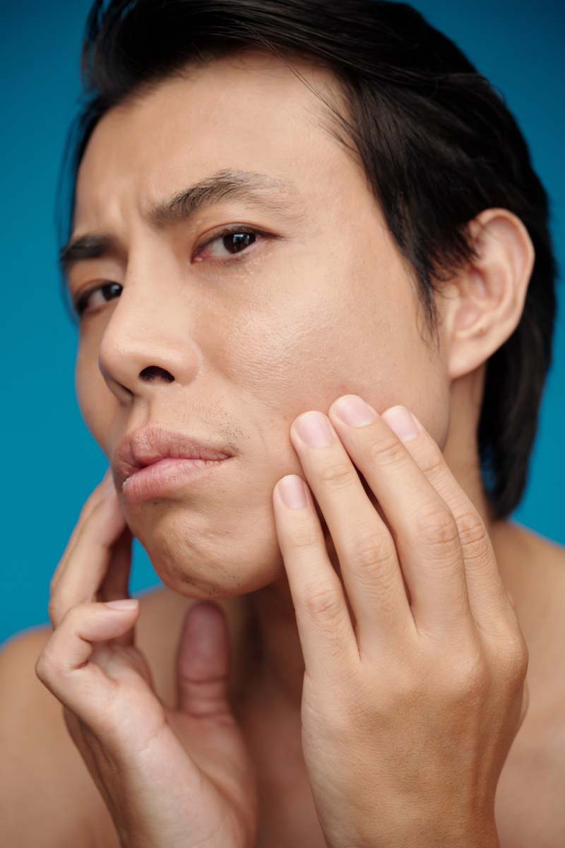 Man applying acne treatment on face after taking morning shower