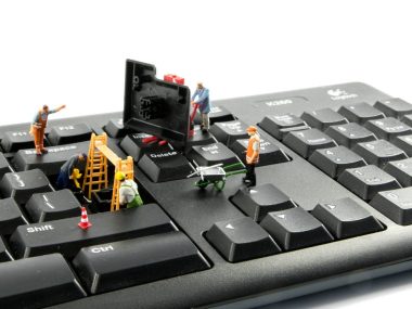 little world figures repairing the key board of the computer or try to hack or intergate in the system