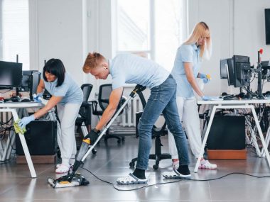 Concentrated at job. Group of workers clean modern office together at daytime.