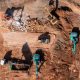 Aerial view road motor grader flatting dirt road surface, Motor grader road construction grader industrial machine construction site new road, Aerial view group excavator working on construction site.